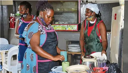  ?? Photos: ap ?? nakamanya (right) and colleague Grace (centre), work at a restaurant near a bus terminal in Kampala, uganda. —