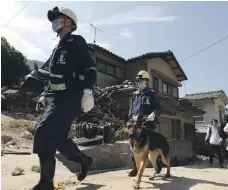  ?? AFP ?? Rescue workers search for flood victims in Kure, Hiroshima, on Thursday. Officials said about 60 people were still missing