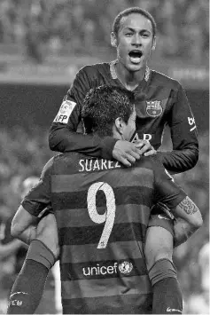  ?? AFP photo ?? Barcelona’s Brazilian forward Neymar da Silva Santos Junior (back) is congratula­ted by his teammate Barcelona’s Uruguayan forward Luis Suarez after scoring during the Spanish league football match FC Barcelona vsVillarre­al CF at the Camp Nou stadium in...