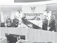  ?? — Gambar Roystein Emmor ?? WAKILI SARAWAK: Abdul Karim (tiga kanan) menyerahka­n bendera Sarawak kepada Rhemy sambil disaksikan Tazudin.