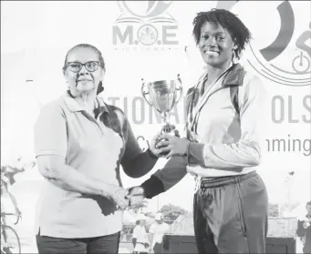  ?? ?? Sprinters Omar James (Boys U-18) of District 10 and Keliza Smith (Girls U-20) of District 3 receiving their respective Champion Boy and Girl trophy for their respective age groups. (Emmerson Campbell photos)