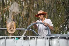  ?? ?? Farmer Nguyen Van Hung fills fresh water into a tank for sale, in Vietnam’s southern Ben Tre province.