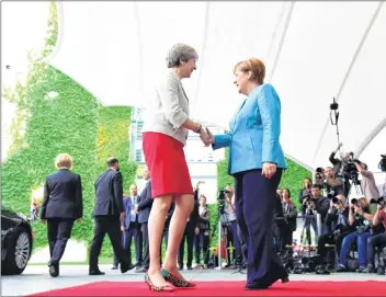  ??  ?? German Chancellor Angela Merkel (right) shakes hands with Britain’s Prime Minister Theresa May to welcome her at the Chanceller­y in Berlin ahead of a meeting with European G20 heads of State.