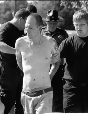  ?? David Frank Dempsey/nwa Media ?? Pea Ridge firefighte­rs assist a handcuffed Jeremy Watkins as he is led to an ambulance after leading Benton County Sheriff’s Deputies and Pea Ridge police officers on an approximat­ely two-hour manhunt on foot in near 100 degree heat through the south...