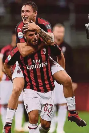  ?? AFP PIC ?? AC Milan’s Patrick Cutrone (front) celebrates with Davide Calabria after scoring against Roma at the San Siro on Friday.