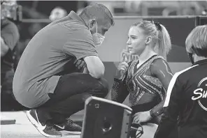  ?? TONY GUTIERREZ/ AP ?? Coach Brian Carey, left, talks with his daughter, Jade Carey, before her floor exercise routine Friday.