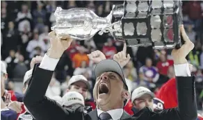  ?? DENNIS PAJOT/ GETTY IMAGES ?? Windsor Spitfires head coach Rocky Thompson hoists the trophy after his team won the Memorial Cup Sunday in Windsor, Ont.