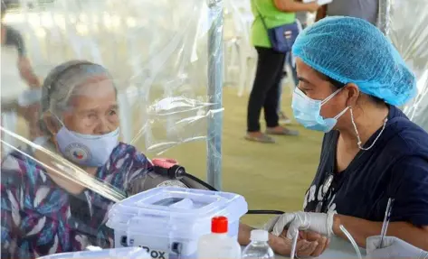  ??  ?? BEFORE THE JAB. (Contribute­d photo)
A health worker in Apalit town checks on the condition of a senior citizen prior to vaccinatio­n.