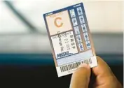  ?? ?? A Metra passenger holds a 10-ride pass as a conductor punches tickets in 2015.