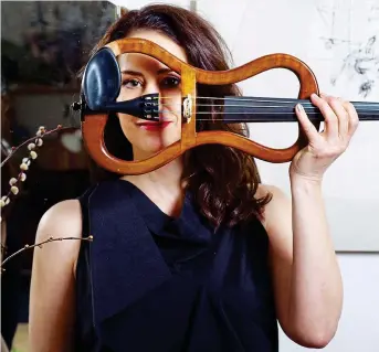  ??  ?? The sound of silence: Musician Monica Germino with the “whispervio­lin” she co-invented