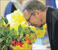  ?? 25_c12guild01 ?? Reverend Philip Wallace sniffs some of the spring blooms on offer.