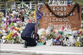  ?? ERIC GAY/AP ?? Reggie Daniels pays his respects Thursday at a memorial at Robb Elementary School in Uvalde, Texas, that was created to honor the victims killed in the shooting.