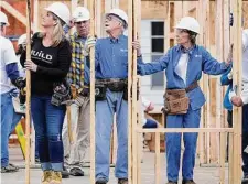  ?? Mark Humphrey/Associated Press file photo ?? Former President Jimmy Carter works between his wife, Rosalynn Carter, right, and singer Trisha Yearwood, left, at a Habitat for Humanity building site on Nov. 2, 2015, in Memphis, Tenn. Behind Yearwood is her husband, singer Garth Brooks.