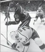  ?? The Canadian Press ?? Vancouver Canucks defenceman Nikita Tryamkin fights for control of the puck against Los Angeles Kings winger Dustin Brown during an NHL game Wednesday in Vancouver. The Canucks won 2-1.