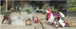  ?? JAWA POS PHOTO ?? DRAMA KOLOSAL: Para siswa SMA Giki 3 menampilka­n aksi teatrikal adegan pertempura­n 10 November di Jalan Klampis Jaya kemarin (11/11).