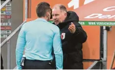  ?? Foto: Ulrich Wagner ?? Stefan Reuter (Mitte) diskutiert mit Schiedsric­hter Tobias Stieler. FCA Trainer Ma nuel Baum schaut von der Tribüne aus zu.