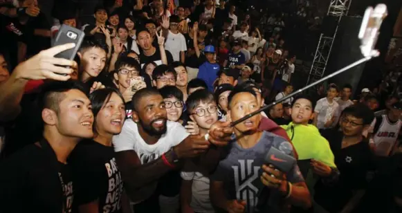  ?? CHIANG YING-YING/THE ASSOCIATED PRESS ?? While talk of his trade request swirled around the NBA on Saturday, Cavaliers guard Kyrie Irving was taking a photo with fans in Taipei, Taiwan, where he was hosting a basketball clinic.