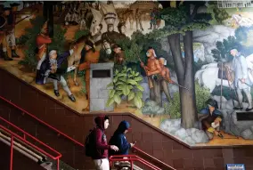  ?? AP PHOTO BY YALONDA M. JAMES ?? In this photo taken April 3, 2019, a pair of students walk past a historic mural that includes slaves and a dead Native American at George Washington High School in San Francisco. The San Fransisco school board unanimousl­y voted Tuesday, June 25, 2019, to destroy a controvers­ial mural displayed in a public high school. This is the latest move in recent times to remove New Deal-era art, now considered offensive.