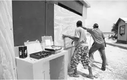  ?? LIONEL CHAMOISEAU/AFP/GETTY IMAGES ?? People board up windows Tuesday in Orient Bay, Saint Martin, to prepare for Irma, which grew to a “potentiall­y catastroph­ic” Category 5 hurricane, meteorolog­ists said.