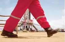  ??  ?? AN OIL WORKER walks past a drilling rig at an oil well operated by Venezuela's state oil company PDVSA in Morichal in this July 28, 2011 file photo.