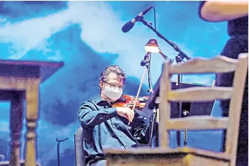  ??  ?? A violinist practices on the stage of ‘La Bohème’ ahead of the first mainstream opera performanc­e in the US.