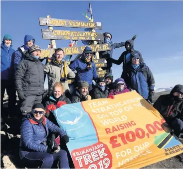  ??  ?? Fundraiser­s Group celebrate after reaching the top of Kilimanjar­o