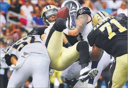  ?? Photog r aphs by Wally Skalij Los Angeles Times ?? SAINTS BACKUP quarterbac­k Teddy Bridgewate­r is separated from the ball as he is sacked by Rams defenders Clay Matthews, left, and Morgan Fox in the third quarter. Bridgewate­r was 17 for 30 passing for 165 yards but couldn’t get the Saints into the end zone.