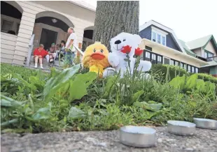  ?? MICHAEL SEARS / MILWAUKEE JOURNAL SENTINEL ?? Flowers, stuffed animals and unlit candles form a memorial in the 3600 block of N. 23rd St., where 6-year-old Justin Evans Jr. was shot and killed on Saturday.