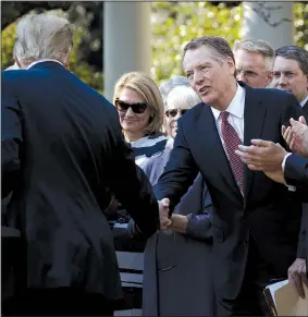  ?? AP/EVAN VUCCI ?? President Donald Trump shakes hands with U.S. Trade Representa­tive Robert Lighthizer during a news conference on the trade agreement between the United States, Canada and Mexico, and the nomination of Judge Brett Kavanaugh to the Supreme Court, in the Rose Garden of the White House on Monday in Washington.