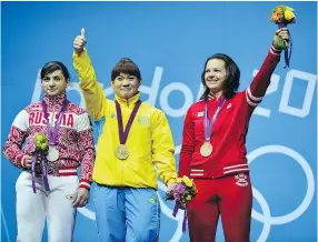  ??  ?? Then-bronze medallist Christine Girard, right, with Kazakhstan’s Maiya Maneza, gold, and Russia’s Svetlana Tsarukaeva, left, with silver, at the London Summer Olympics in 2012.