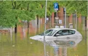  ?? (AFP) ?? A car is seen in a flooded supermarke­t area after heavy rains caused major floodings in Italy on Wednesday