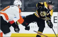  ?? MICHAEL DWYER — THE ASSOCIATED PRESS ?? Boston’s Brad Marchand, right, takes a shot as the Flyers’ Robert Hagg defends during the second period Saturday.