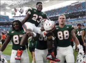  ?? LYNNE SLADKY — THE ASSOCIATED PRESS ?? Miami tight end Christophe­r Herndon IV (23) is carried off the field by his teammates after Saturday’s win against Virginia in Miami Gardens, Fla.