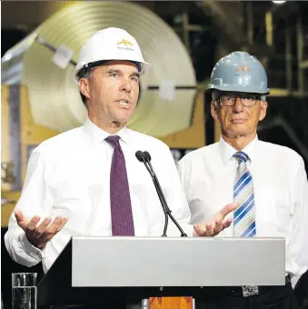  ?? PETER POWER/THE CANADIAN PRESS ?? Finance Minister Bill Morneau announces Tuesday that he will evaluate potential safeguards on seven steel products during a 15-day consultati­on. Morneau was accompanie­d by MP Bob Bratina, right, among other leaders, as he toured ArcelorMit­tal Dofasco’s steel mill in Hamilton, Ont.