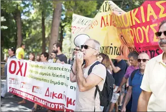  ??  ?? Protesters shout anti-austerity slogans, holding a banner that reads in Greek ‘No to extortiona­te taxation and foreclosur­es,’ outside the Justice Ministry in Athens on Aug 31. About 100 people took part in the peaceful protest against government plans...