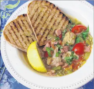  ?? SARA MOULTON VIA AP ?? Clam, tomato and bacon stew with grilled garlic bread from a recipe by Sara Moulton.