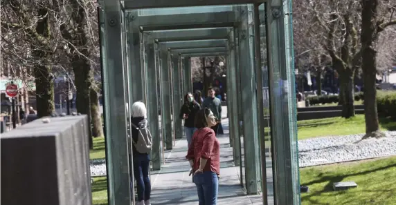  ?? NiCOLAuS CzARnECki pHOTOS / HERALD STAFF ?? ‘SPEAK UP’: People visit the Holocaust Memorial in downtown Boston on Thursday. At top, a bouquet of flowers was left at the site on Holocaust Remembranc­e Day.