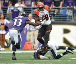  ??  ?? Cincinnati Bengals wide receiver A.J. Green breaks a tackle by Baltimore Ravens strong safety Will Hill (33) and cornerback Jimmy Smith (22) and carries the ball into the end zone for a touchdown.