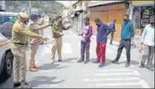  ??  ?? ■
Police officials warn curfew violators at a market in Shimla on Sunday. DEEPAK SANSTA/HT