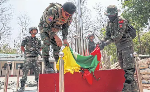  ?? REUTERS REUTERS ?? A soldier of the Karen National Liberation Army (KNLA) burns Myanmar’s national flag at a military base on the outskirts of Myawaddy.