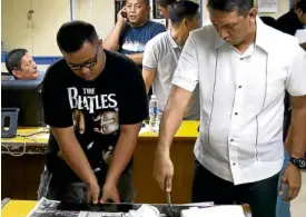  ??  ?? John Paul Solano, the principal suspect in the killing of Horacio Castillo III, undergoes fingerprin­ting procedure at the Manila Police District headquarte­rs.