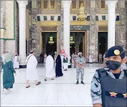  ?? KUNA photo ?? Security forces maintainin­g strict health precaution­ary measures and physical distancing between pilgrims at the ‘Bab Al-Fahd’ (Fahd Gate) at the Grand Mosque in Makkah, Saudi Arabia. The annual Hajj pilgrimage (Arafat Standing) falls on Monday, July 19, 2021.