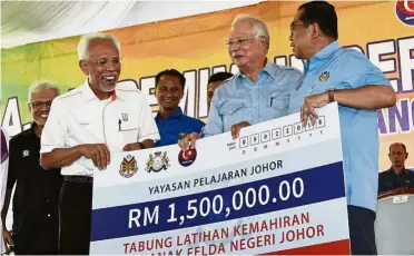  ??  ?? For youths: Najib looks on as Johor Mentri Besar Datuk Mohamed Khaled Nordin (right) presents a RM1.5mil mock cheque to Felda chairman Tan Sri Shahrir Abd Samad (left).