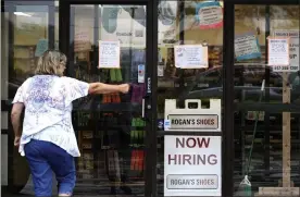  ?? Ap File ?? a woman looks a ‘now hiring’ sign. president of the retailers associatio­n of massachuse­tts Jon Hurst said ‘you’d be hard-pressed to find any industry that is fully staffed right now’ as the labor shortage overlaps with unemployme­nt expiration­s.