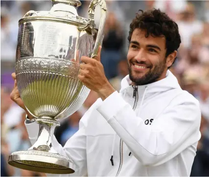  ?? GETTY IMAGES ?? Grinning feeling: Berrettini smiles to the crowd as he lifts the trophy at Queen’s Club