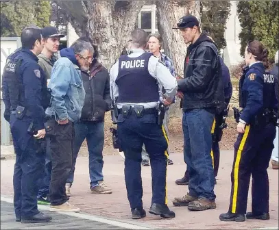  ?? JOE FRIES/Penticton Herald ?? Police outside the Penticton courthouse on Tuesday question a man who was mistaken for the subject of a threats complaint that triggered a partial lockdown of nearby City Hall.