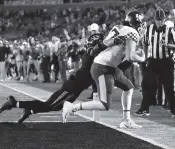  ?? JAMIE SQUIRE Getty Images ?? Kentucky tight end C.J. Conrad catches the game-winning touchdown pass in the end zone as time expires while Missouri safety Tyree Gillespie tries to defend on Saturday in Columbia, Missouri.