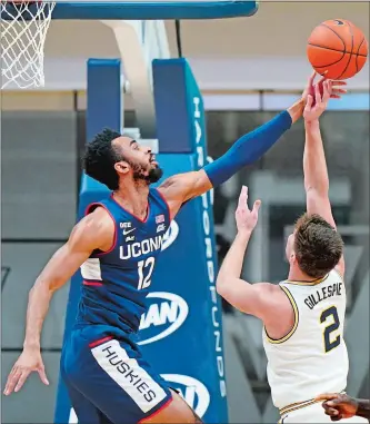  ?? MATT SLOCUM/AP PHOTO ?? UConn’s Tyler Polley, left, blocks a shot by Villanova’s Collin Gillespie during the second half of Saturday’s Big East game in Villanova, Pa. The 10th-ranked Wildcats remained in first place by pulling away late for a 68-60 victory over the Huskies.