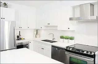  ??  ?? The kitchen backsplash has white ‘ penny round’ tiles and square, undermount sinks.