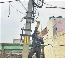  ?? SNIGDHA POONAM/HT ?? (From left) A line man from the Noida Power Corporatio­n Limited removes unauthoris­ed cables in Greater Noida’s Surajpur village, a task that officials say puts them on the receiving end of people’s anger